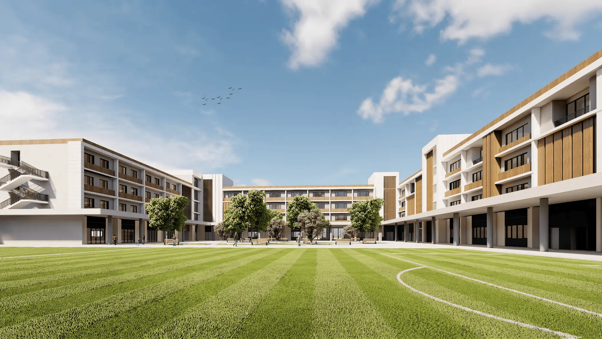 A modern school building with three storeys surrounds a large, well-maintained grassy courtyard at Rugby School Nigeria, under a partly cloudy sky.
